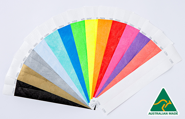 A collection of mixed-colour Tyvek wristbands on a white surface.