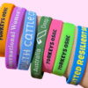 A person wearing a collection of custom glitter-finish wristbands.