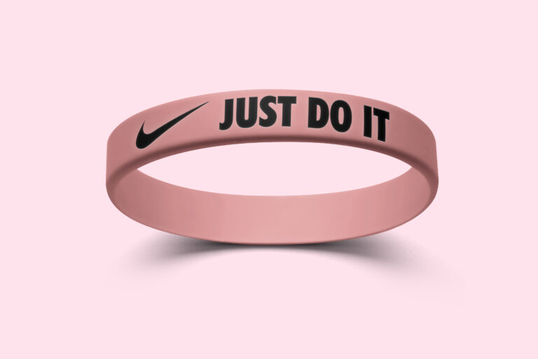 A pink silicone wristband with the Nike logo that features the phrase "Just Do It."