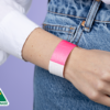 A woman wearing a plain neon pink wristband on her wrist.