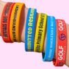 A person wearing a selection of custom silicone wristbands.
